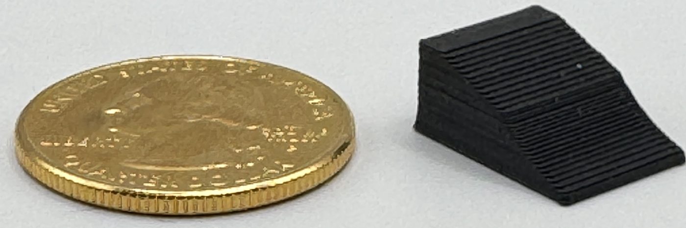 Scale wheel chock next to a US quarter for size